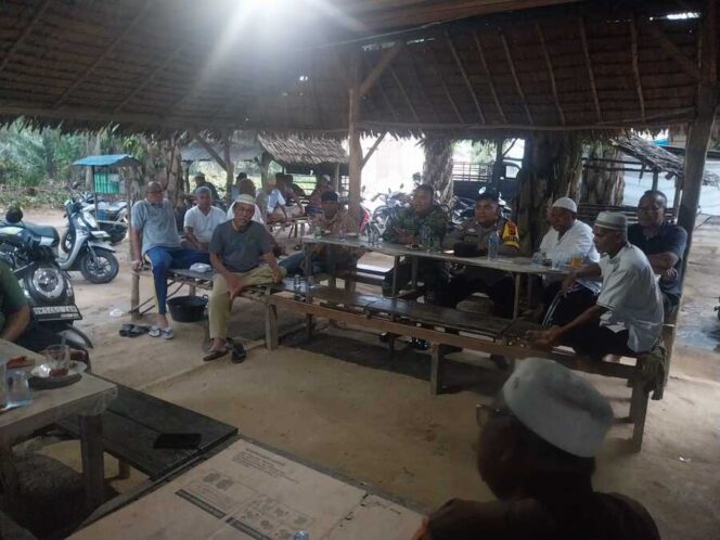 
					Babinsa Koramil 12/Lap Serda Edy Harahap menghadiri rapat bersama warga di Warung Kopi milik Amrin Siregar, Sabtu (18/10/2025)