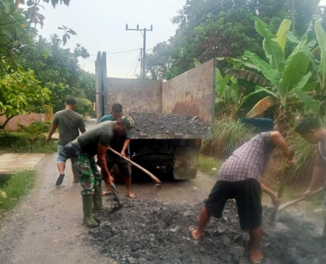 
					Sertu Ari Gunawan, bersama warga Dusun II Kampung Lalang bergotong royong memperbaiki jalan yang rusak, Minggu (02/11/2025)