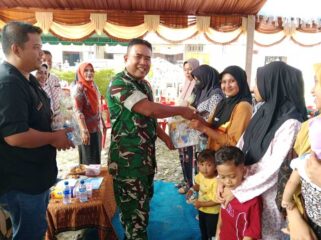 Danramil 09/NL Kapten Cba. P. Matondang, S.H., M.H saat memberikan bingkisan kepada warga dalam Program operasi katarak gratis