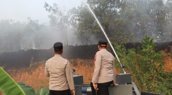Diatas Water Cannon Kapolres Labuhanbatu AKBP Wahyu Endrajaya turun langsung memantau proses pemadaman