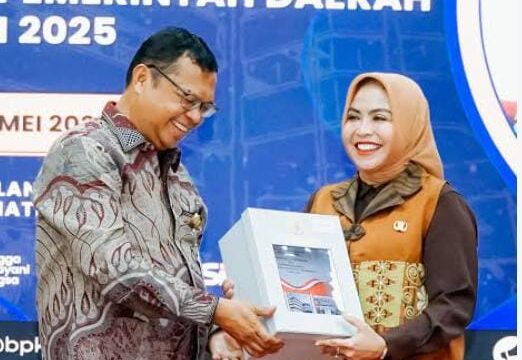 Keterangan Foto: Kepala BPK RI Perwakilan Sumut Paula Henry Simatupang menyerahkan penghargaan Opini WTP LKPD TA 2025 kepada Bupati Labuhanbatu dr. Hj. Maya Hasmita, Sp.OG., M.K.M.